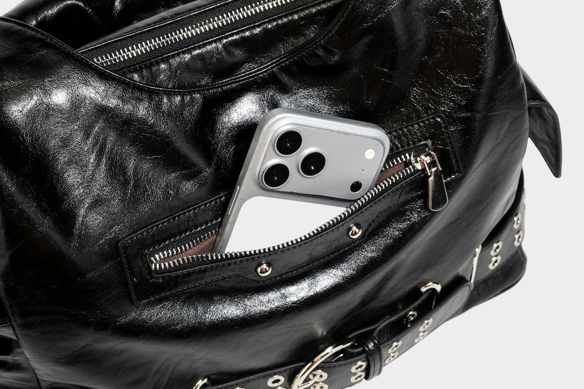 Große glänzende schwarze Hobo-Schultertasche mit silberfarbenem Ösen-Gürtelboden, Schnallenbeschlägen, vorderer Reißverschlusstasche und zwei …; Detailansicht