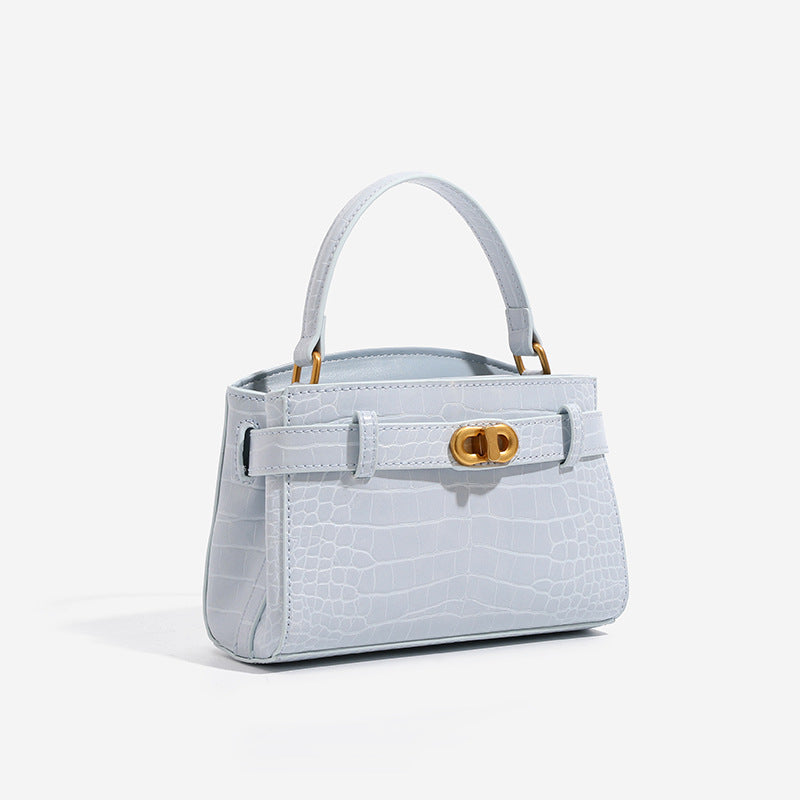 Small structured crocodile-embossed top-handle bag with gold-tone turn-lock closure and detachable shoulder strap, detail