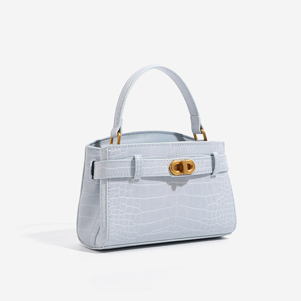 Small structured crocodile-embossed top-handle bag with gold-tone turn-lock closure and detachable shoulder strap, detail