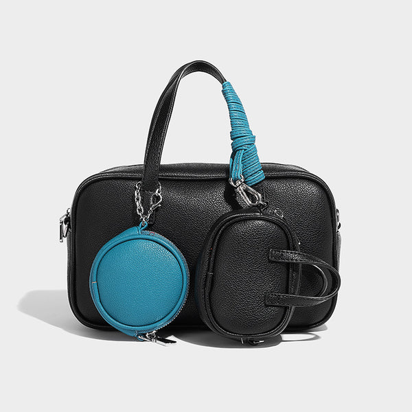Structured pebbled leather-look Boston bowling bag in tan with blue detachable round mini pouch, dual top handles, and