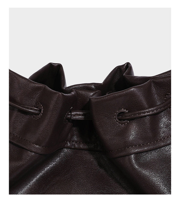 Slouchy drawstring bucket bag in dark brown leather-look finish with long adjustable shoulder strap and gathered tie closure