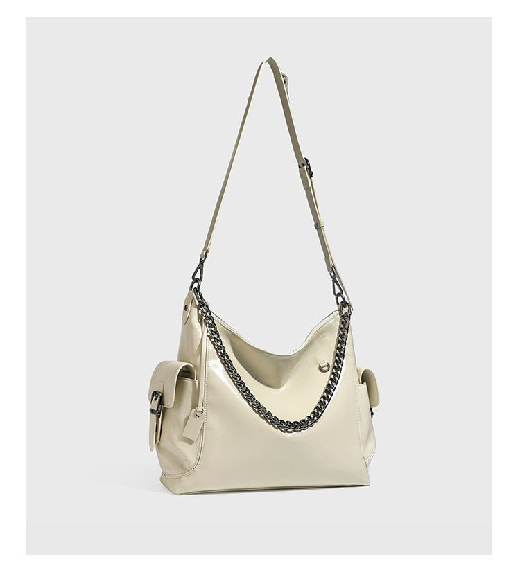 Slouchy hobo shoulder bag with glossy leather-look finish, silver-tone chain drape across front, side buckle pockets, and