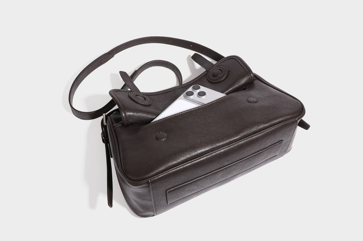 Formstabile rechteckige Schultertasche mit vorderem Überschlag in dunkler Espresso-Lederoptik, silberfarbenen Beschlägen und langem