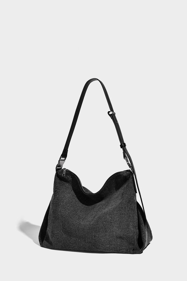 Charcoal denim-textured slouchy hobo bag with zip-top closure, silver-tone hardware, and adjustable leather-look crossbody