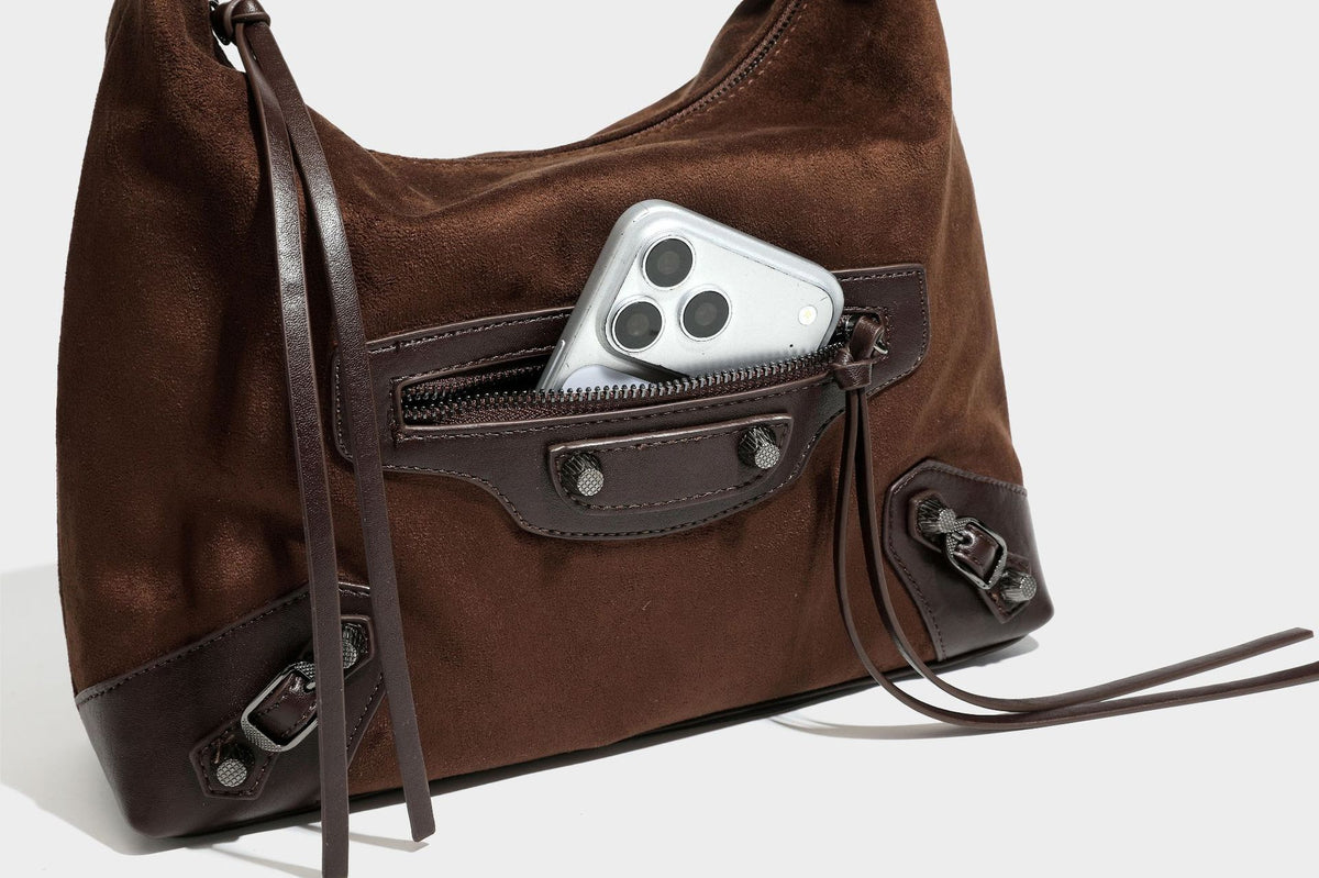 Slouchy suede-finish hobo shoulder bag with dark hardware, exterior zip pocket, tassel ties, and detachable crossbody strap