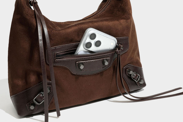 Slouchy suede-finish hobo shoulder bag with dark hardware, exterior zip pocket, tassel ties, and detachable crossbody strap