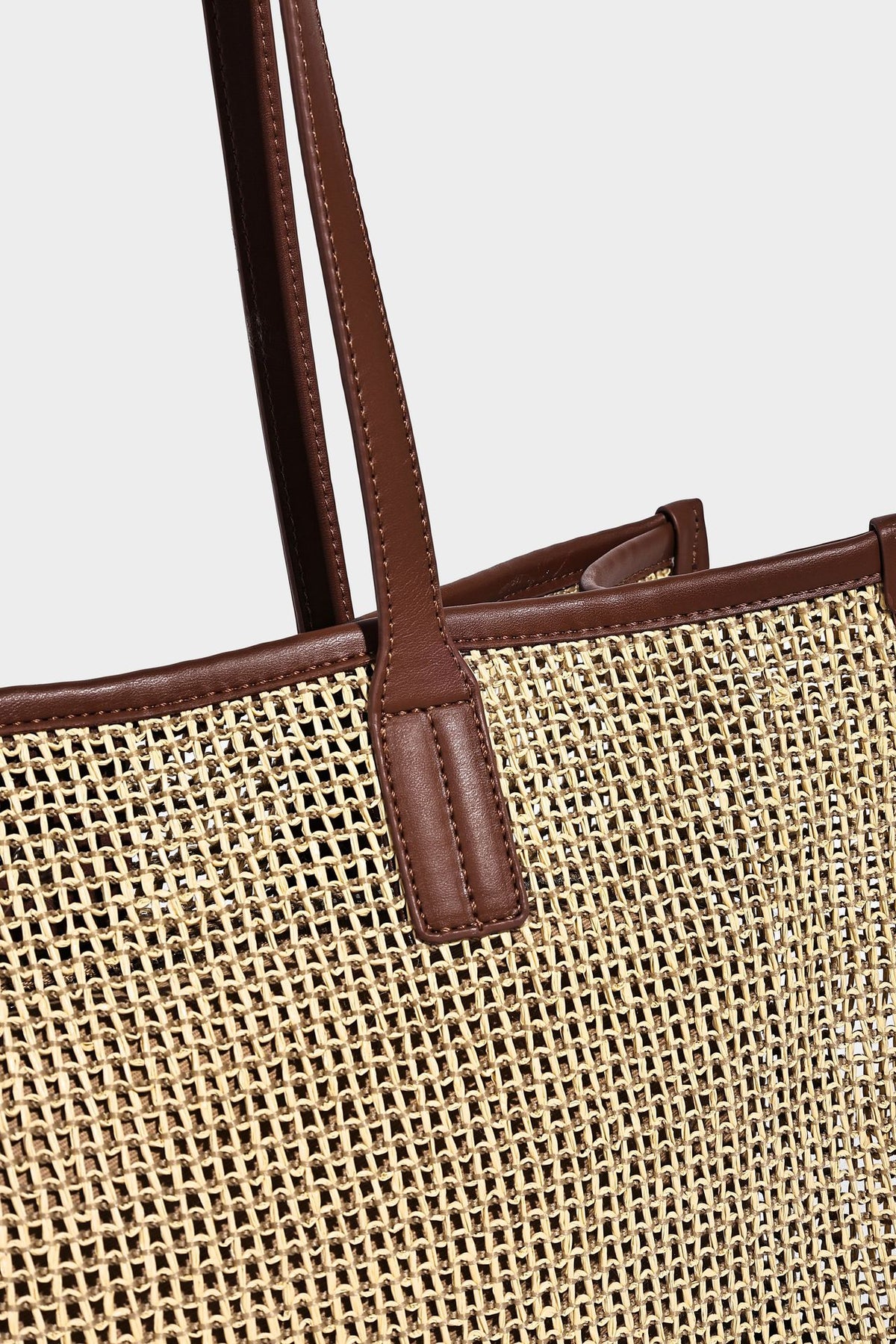 Große Tote-Bag aus grob geflochtenem Stroh in Beige und Creme mit dunkelbraunen Details in Lederoptik, langen Schulterriemen und einem mit Perlen verzierten
