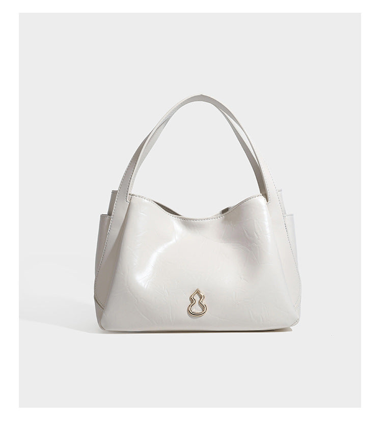 Black glossy crinkled leather-look convertible shoulder tote bag with gold gourd-shaped emblem hardware and detachable