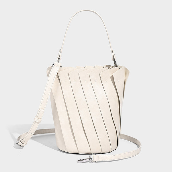 Structured pleated-panel bucket bag with curved top handle and detachable adjustable shoulder strap in smooth matte, detail