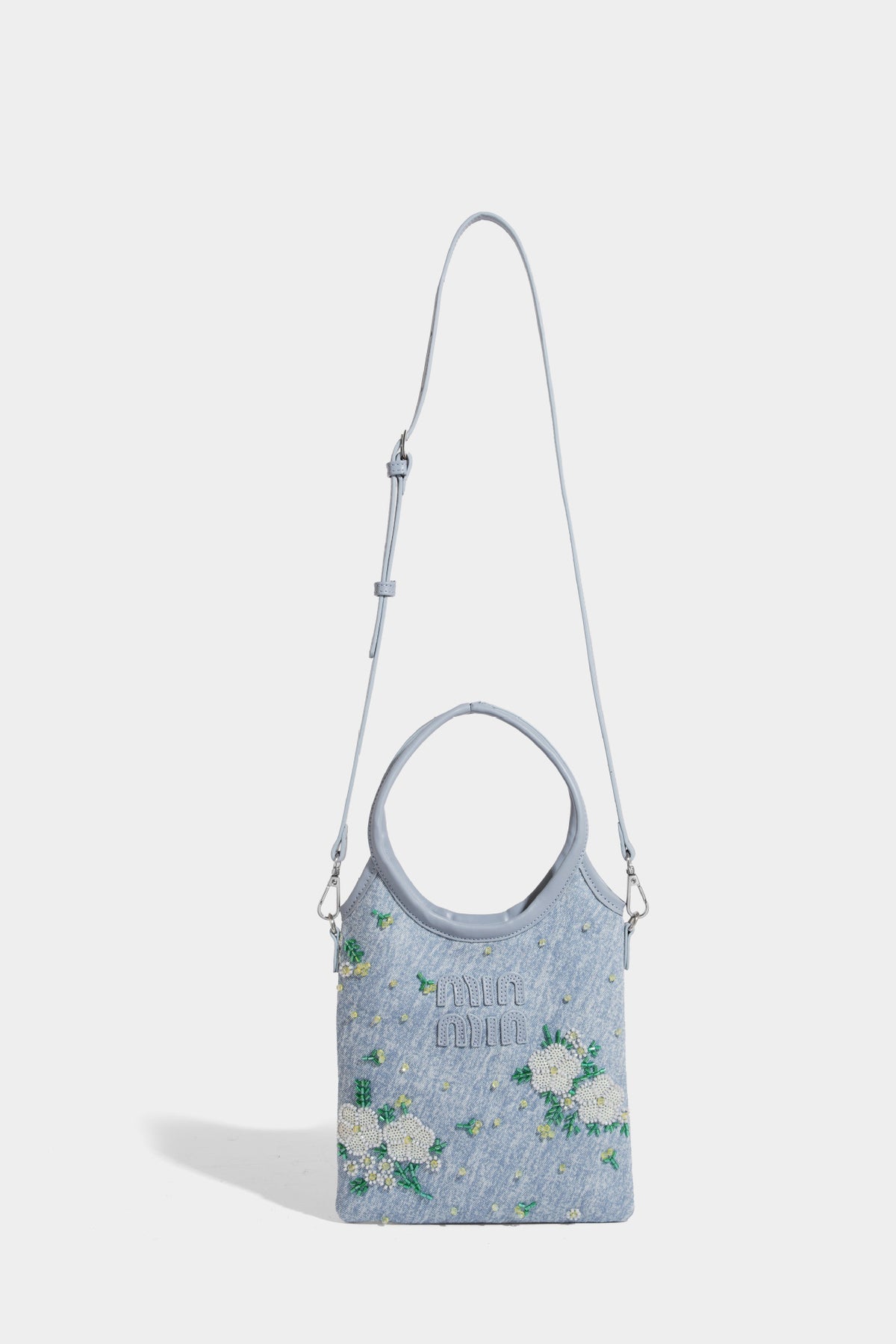Kleine hellblaue Mini-Tote-Bag aus Stoff mit weißer Perlenblumenverzierung, runden Henkeln, silberfarbenen Beschlägen und