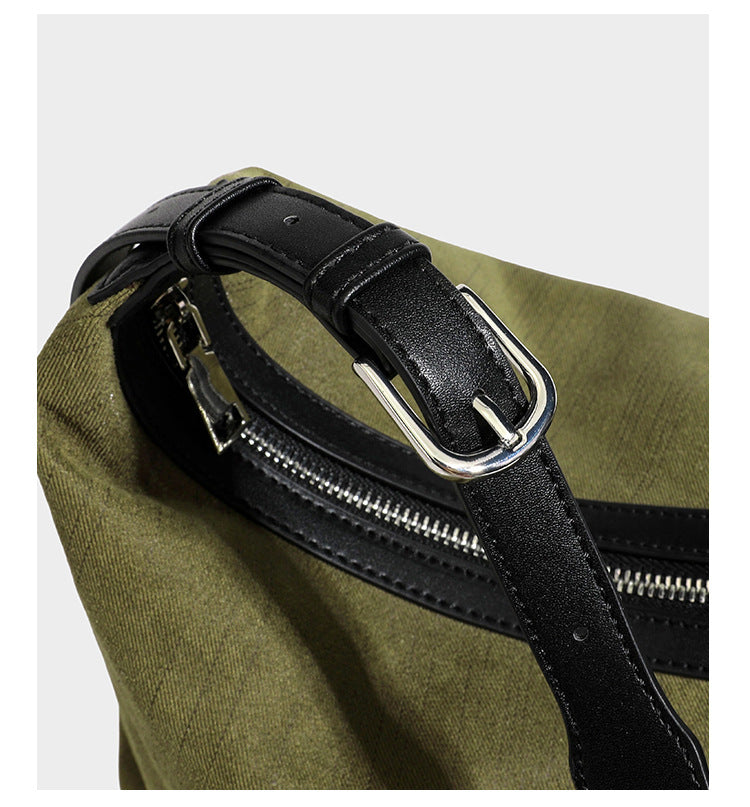 Slouchy olive green canvas hobo shoulder bag with black leather-look trim, zip-top closure, and adjustable strap, detail view