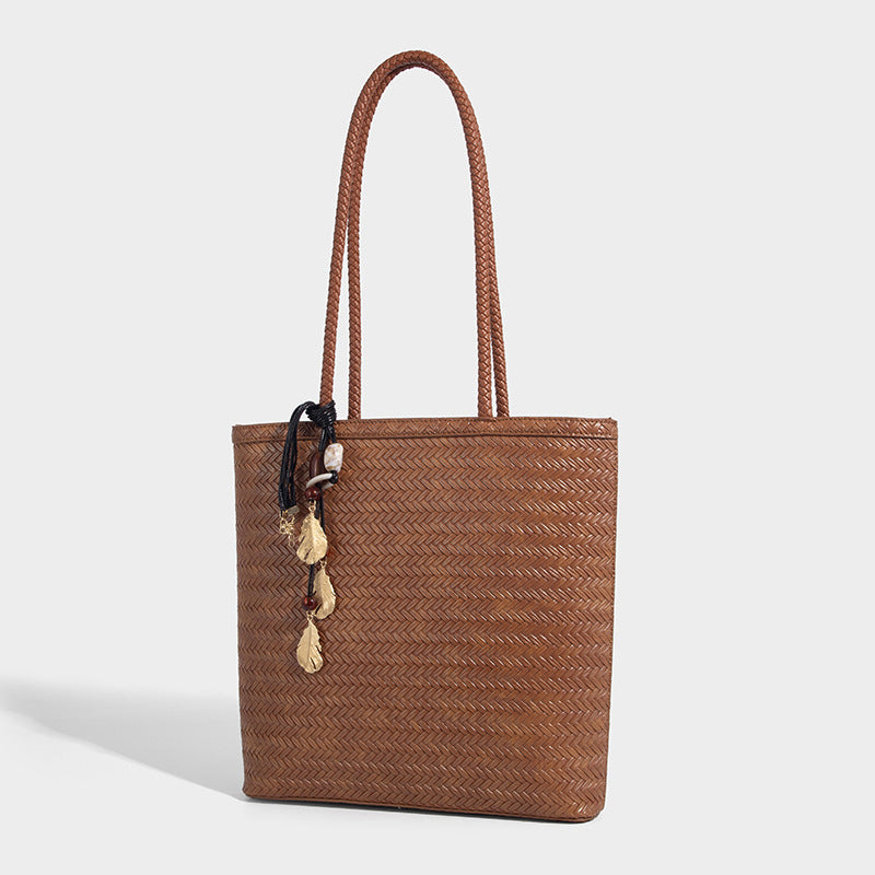 Structured woven herringbone tote bag with braided double shoulder handles in tan brown, shown with matching drawstring