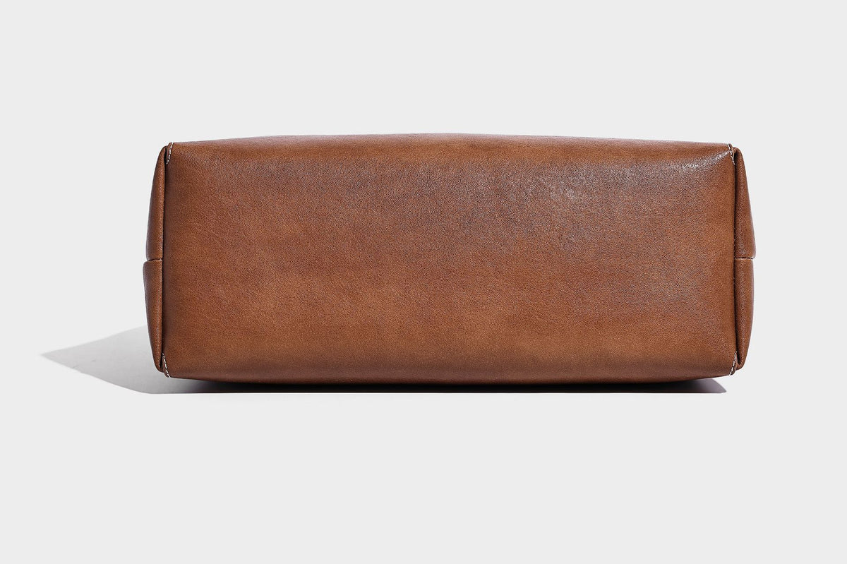 Große, strukturierte Schultertasche im Tote-Stil in Braun und Lederoptik mit langen Doppelriemen, Schnallenbeschlägen, Quasten-Anhänger und geschwungener