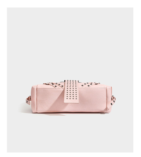 Structured pink leather-look satchel bag with gunmetal studded trim, rectangular buckle strap, dual top handles, and, detail