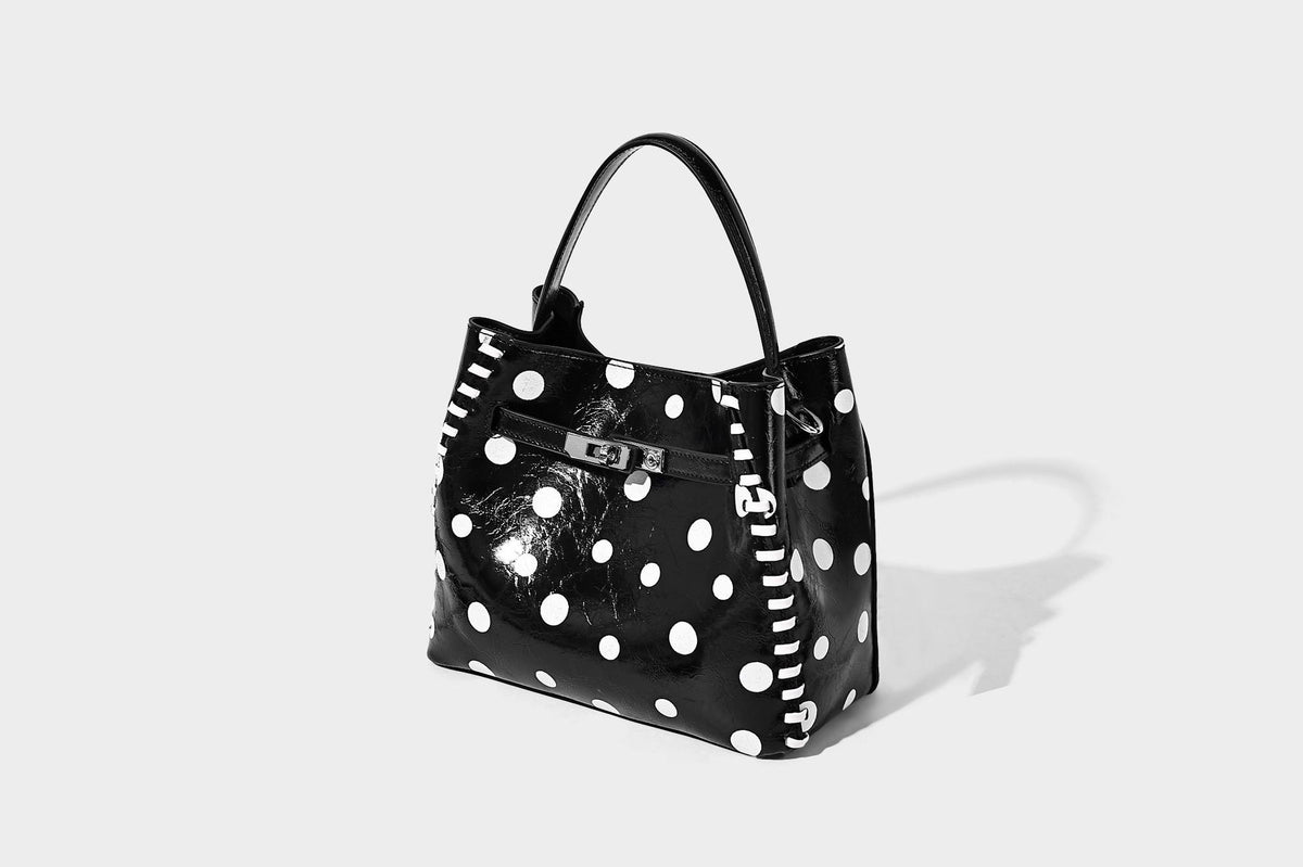 Glänzende, geknautschte Beuteltasche mit Polka-Dots, silberfarbenen Schnallenbeschlägen, kontrastierendem seitlichem Schnürbesatz, Tragegriff und abnehmbarem