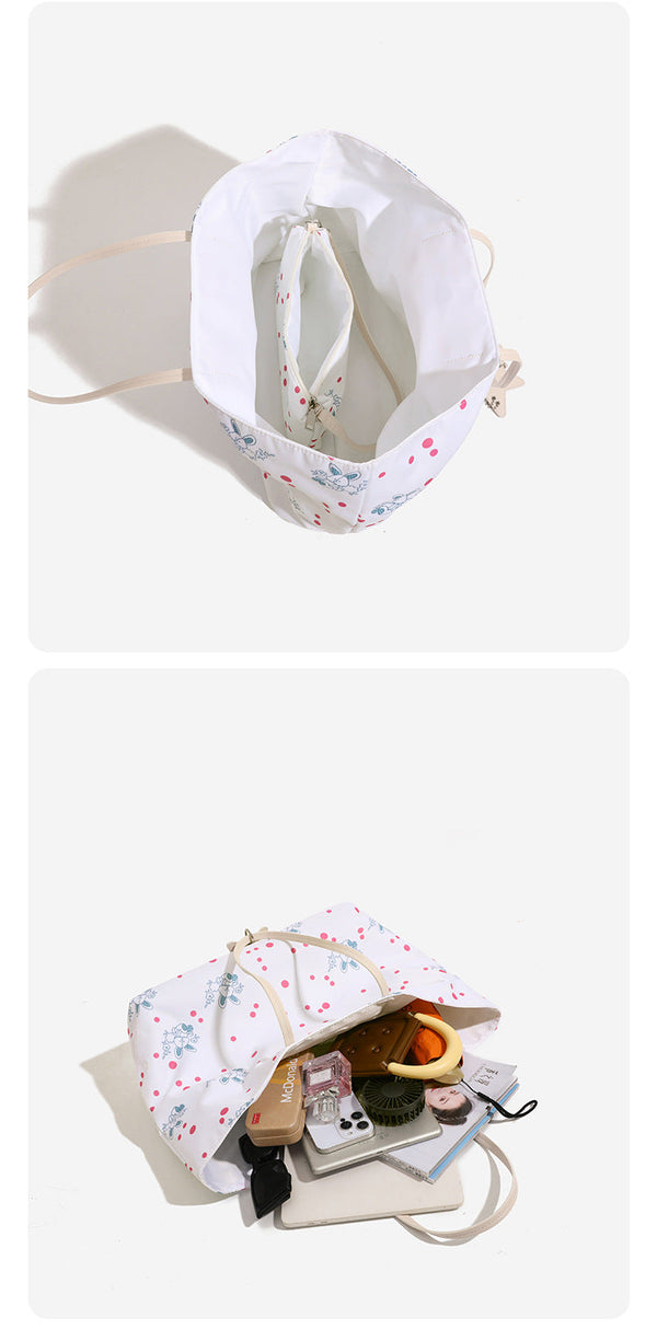 Large reversible floral print tote bag with slim shoulder straps, star charm hardware, and matching zip pouch, detail view 11