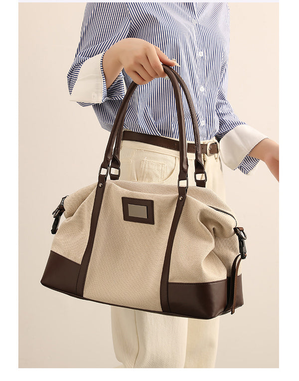 Large cream canvas tote bag with dark leather-look trim, dual top handles, and detachable shoulder strap, detail view 9