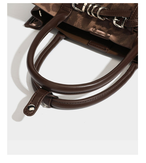Structured leopard-print tote bag with glossy satin-like finish, dual rounded top handles, silver buckle-and-ring front