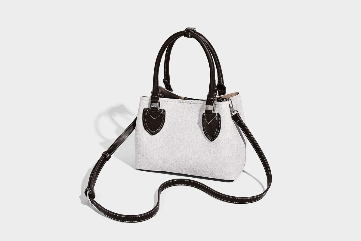 Structured light-blue denim-look tote bag with black leather-look handles, white contrast stitching, silver-tone hardware