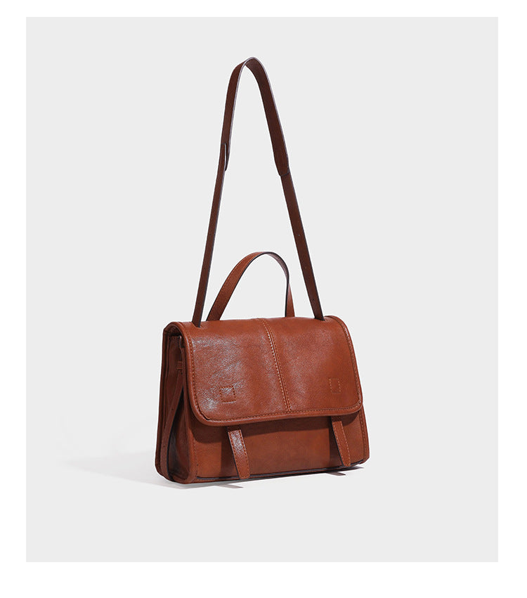 Strukturierte Satchel-Tasche mit Überschlag aus dunkelbrauner, glänzender Lederoptik, kurzem Tragegriff und langem, verstellbarem Schulterriemen
