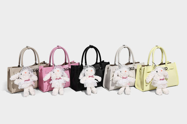 Structured trapezoid tote bag in pebbled leather-look finish with double top handles, silver-tone bar hardware, and, detail