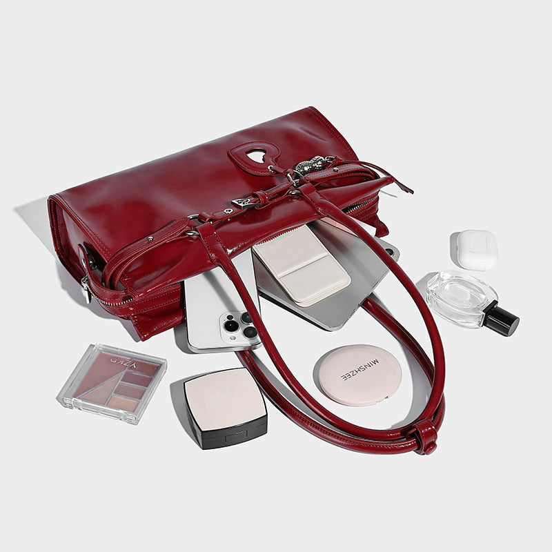 Structured rectangular glossy tote shoulder bag with belt buckle front strap and dangling charm hardware, detail view 3
