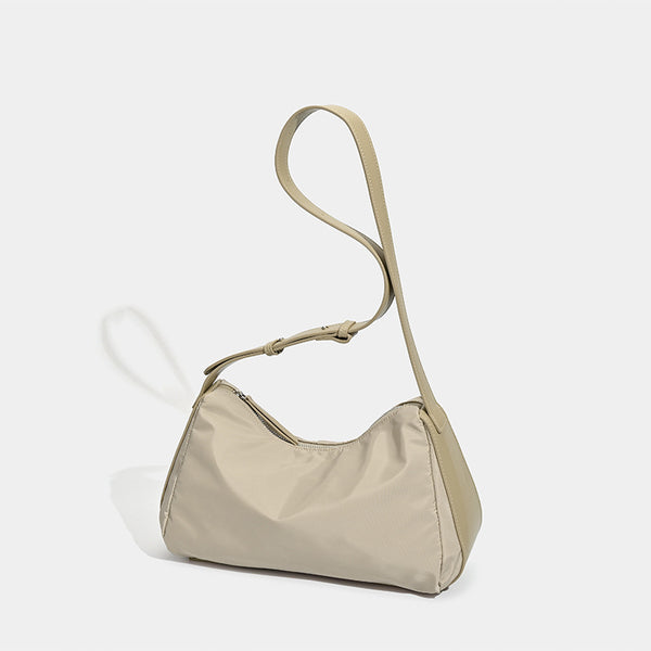 Soft crescent shoulder bag in smooth sheen nylon with contrast leather-look trim, slim adjustable strap, and top zip closure