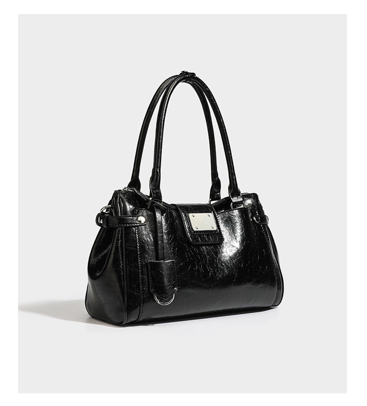 Structured glossy crinkled leather-look satchel with double top handles, front metal-plaque tab, silver-tone hardware, and