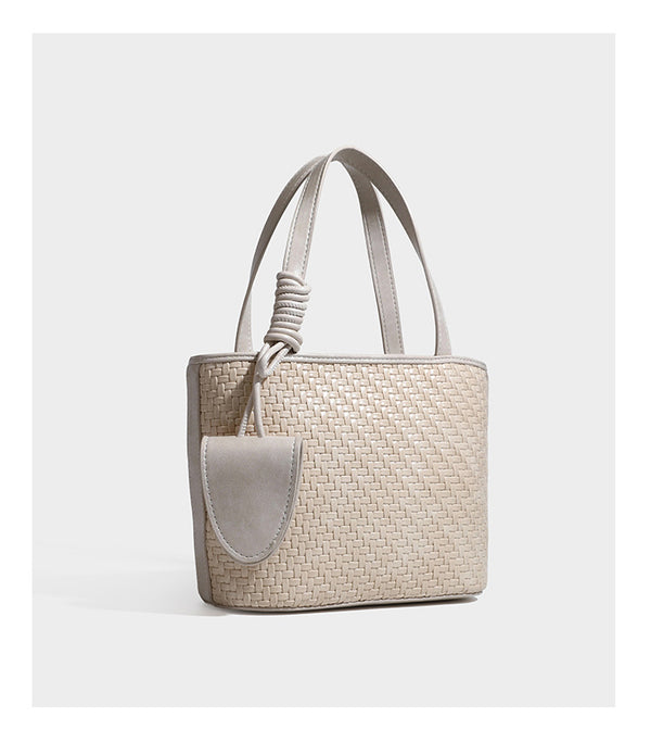 Strukturierte Tote Bag mit gewebter Oberfläche in Braun, goldfarbenen Metalldetails, seilumwickelten Tragegriffen, einer kleinen Fronttasche und weiteren Details