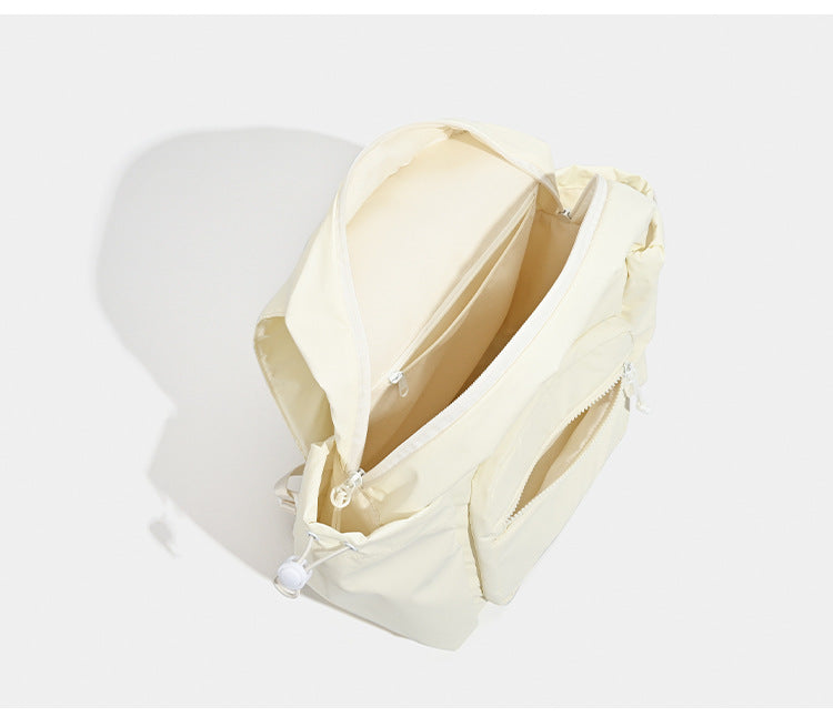 Soft matte nylon flap backpack with front zip pocket and side drawcord pockets, detail view 8