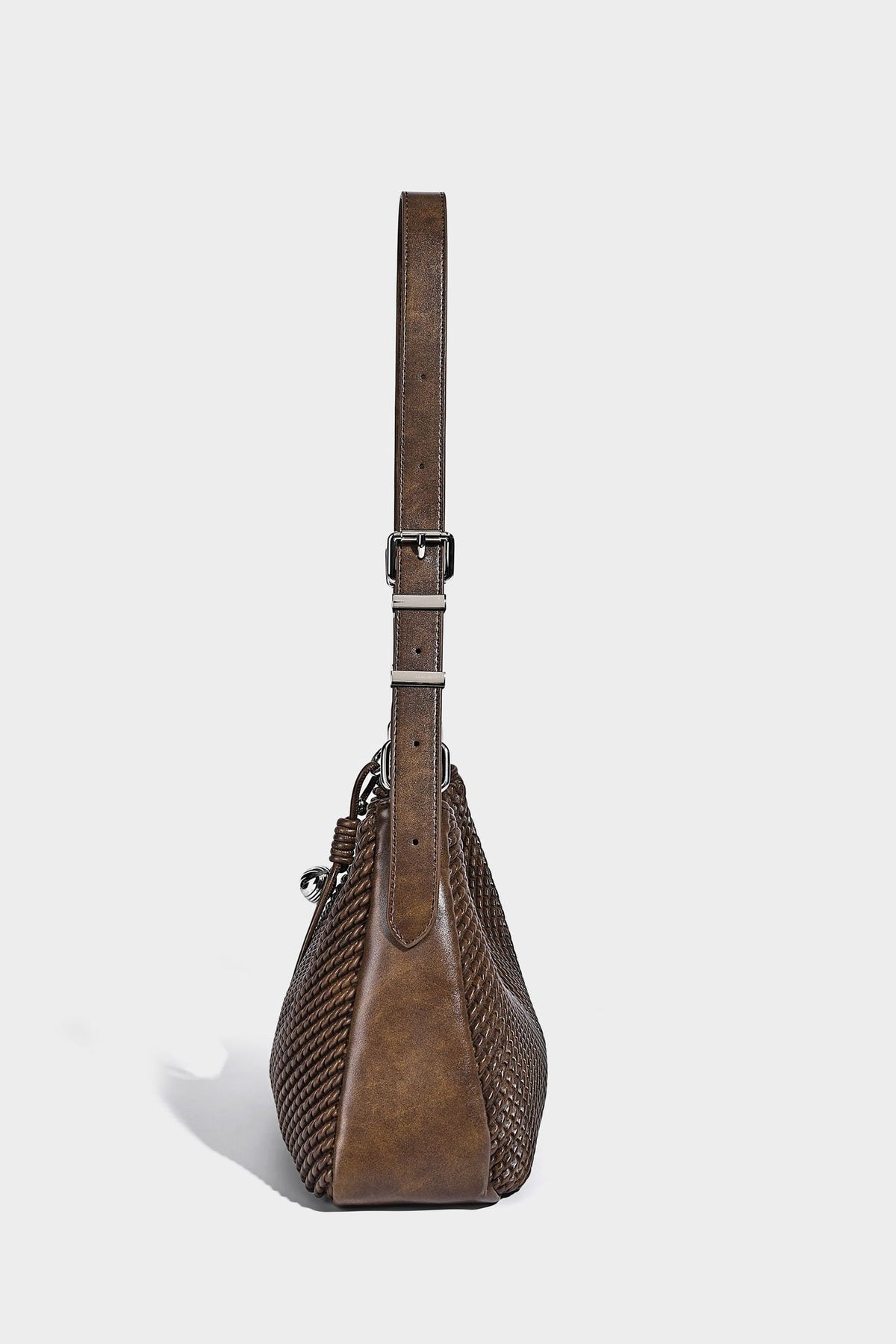 Woven crescent hobo shoulder bag with smooth side panels, zip-top closure, silver-tone charm hardware, and adjustable, detail