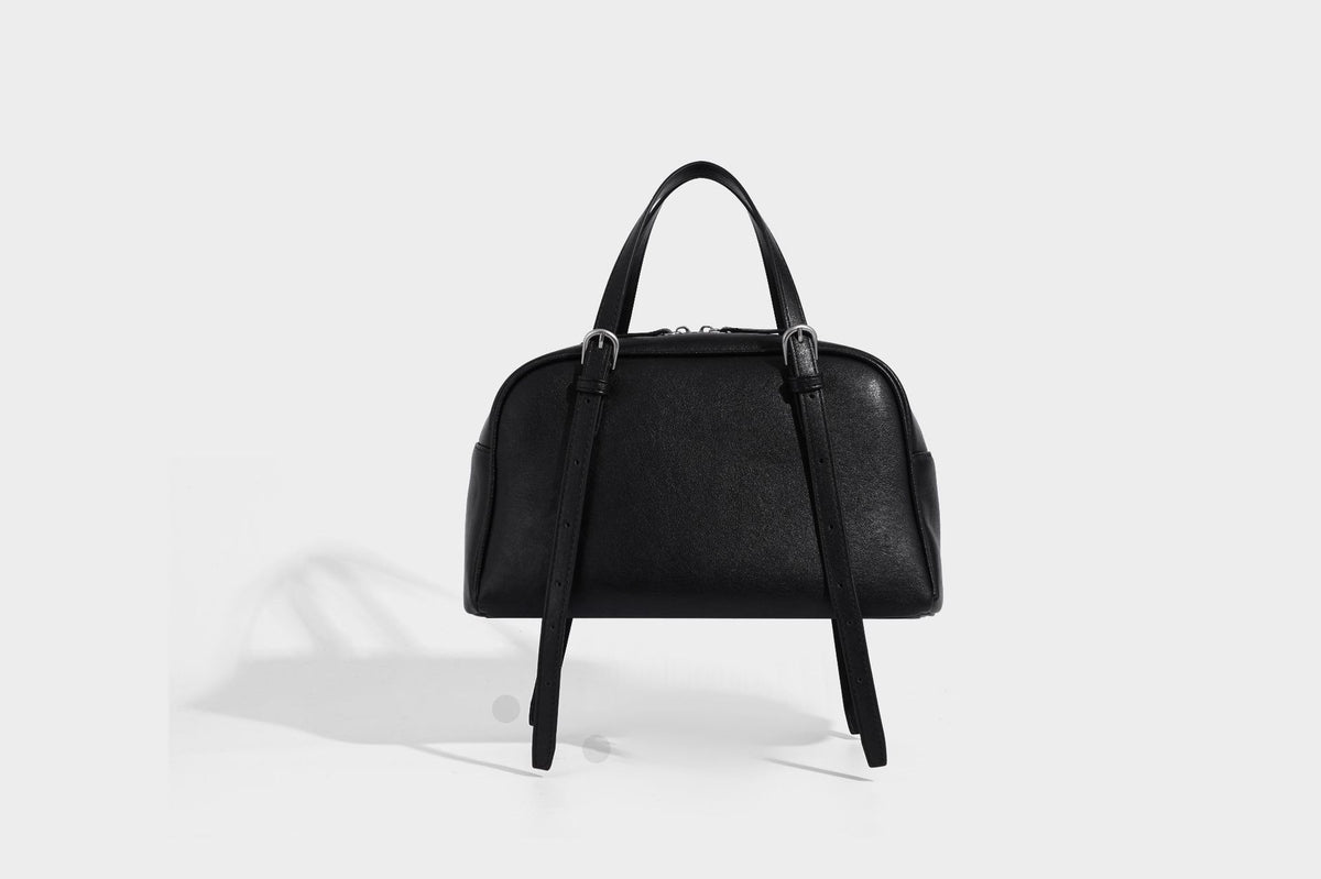 Structured dome-shaped shoulder bag with leather-look finish, top zipper closure, dual adjustable slim straps, and, detail