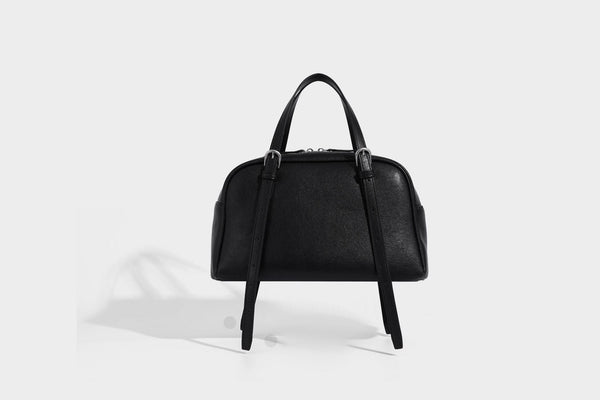Structured dome-shaped shoulder bag with leather-look finish, top zipper closure, dual adjustable slim straps, and, detail