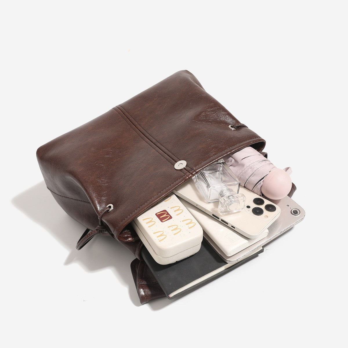 Strukturierte Rucksacktasche mit Überschlag in Used-Lederoptik, seitlichen Kordelzügen und silberfarbenen Beschlägen, Detailansicht