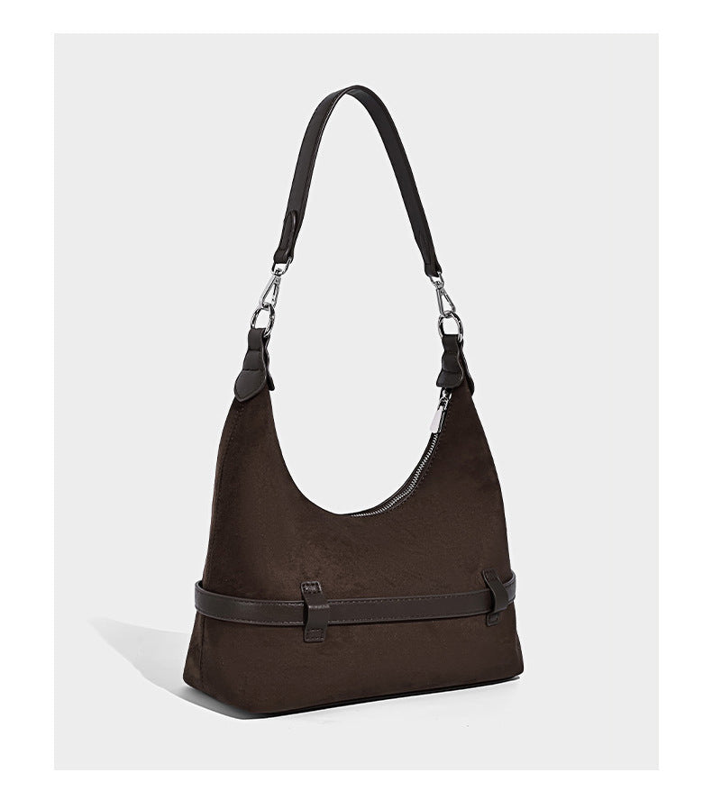 Hobo-Schultertasche in Dunkelbraun mit velourslederartiger Oberfläche, silberfarbener Gürtelschnalle und Ösenbeschlägen, verstellbarem Riemen, Detailansicht