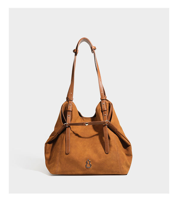 Oversized suede-finish tote shoulder bag in caramel brown with slim leather-look straps and gold-tone logo hardware, detail