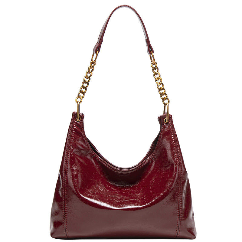 Glossy leather-look hobo shoulder bag with gold-tone chain-and-leather strap in deep burgundy red, detail view 5