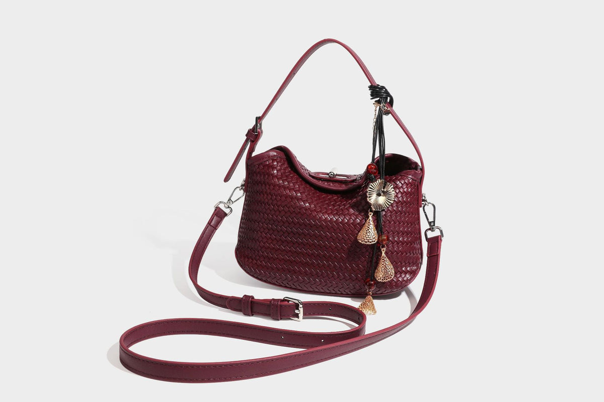 Small woven-look leather-look flap shoulder hobo bag in burgundy with silver-tone hardware and decorative tassel charm