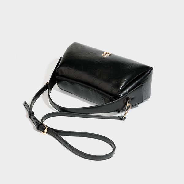 Glänzende, geknautschte trapezförmige Schultertasche mit Klappverschluss, goldfarbenen Logo-Details, Tragegriff und abnehmbarem, verstellbarem