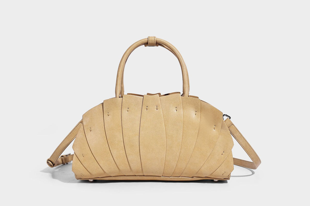 Structured dome satchel with fan-pleated leather-look exterior, dual top handles, and detachable shoulder strap, detail view