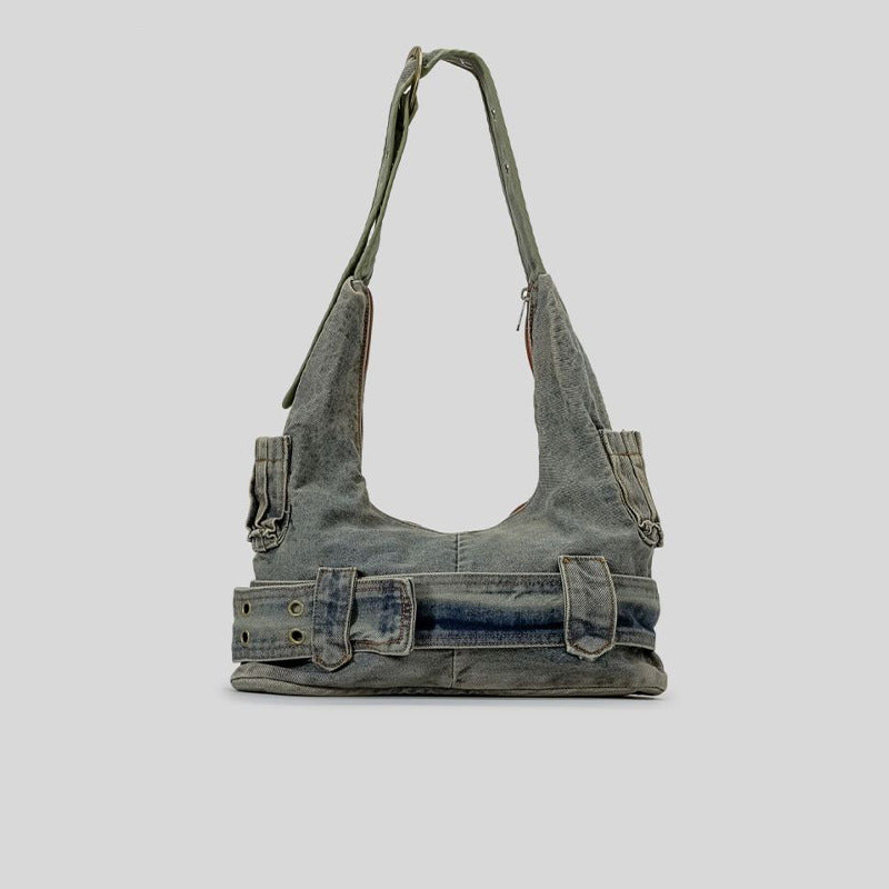 Washed blue-gray denim slouchy hobo shoulder bag with wide grommeted belt panel, brass-tone D-ring buckle, exterior zip