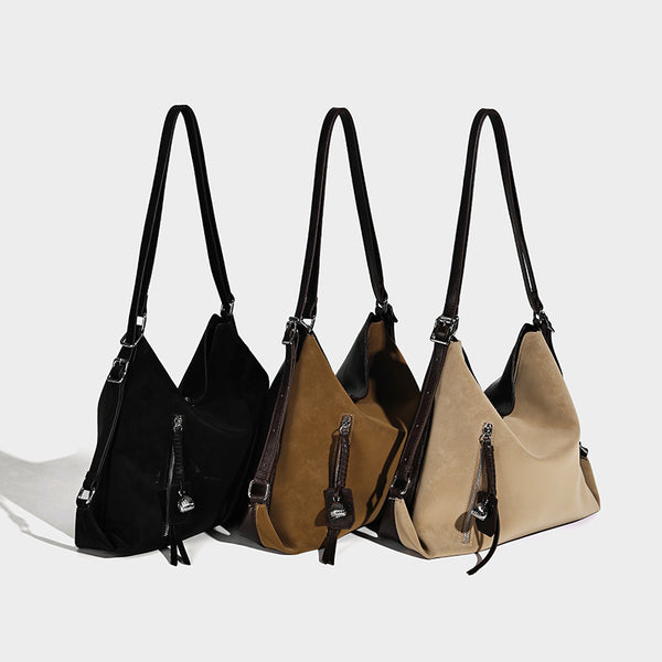 Slouchy hobo tote bag with matte leather-look finish, triangular silhouette, front zip pocket, and adjustable shoulder strap