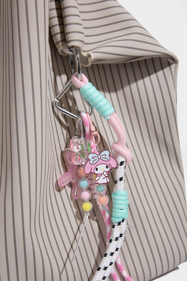 Slouchy pinstripe tote bag with braided rope handles, metal ring hardware, and colorful knotted rope charm, detail view 23