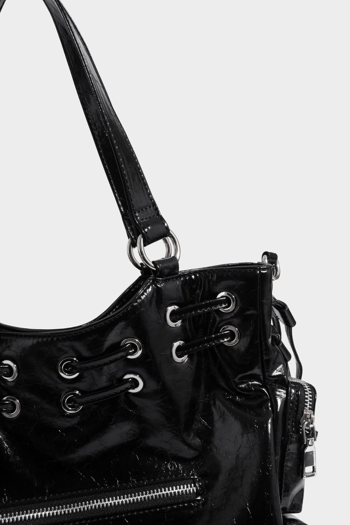 Glossy crinkled leather-look tote bag with silver grommet lace-up front detail, dual top handles, and detachable shoulder