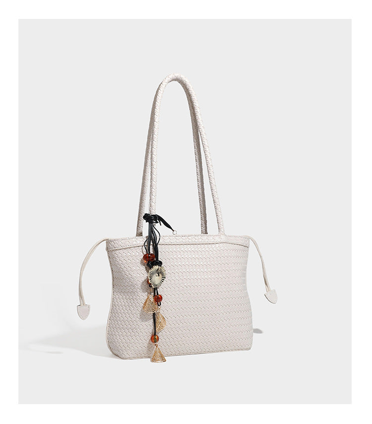Structured woven leather-look tote bag in dark brown with long shoulder straps, side drawstring ties, and gold filigree