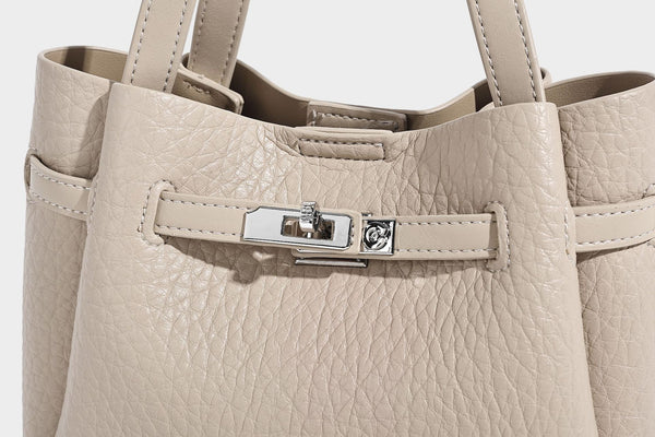 Small structured pebbled bucket tote with double top handles, silver turn-lock hardware, and detachable shoulder strap