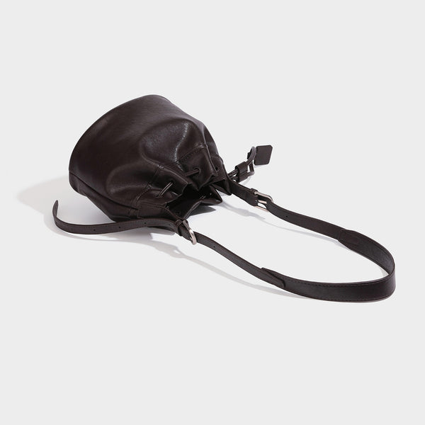 Kleine dunkelbraune Beuteltasche mit langem verstellbarem Crossbody-Riemen und silberfarbenen Beschlägen, Detailansicht 4