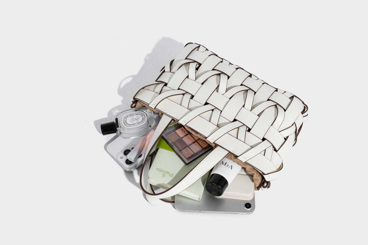 Structured woven basket tote handbag with contrasting dark trim, double top handles, detachable shoulder strap, and