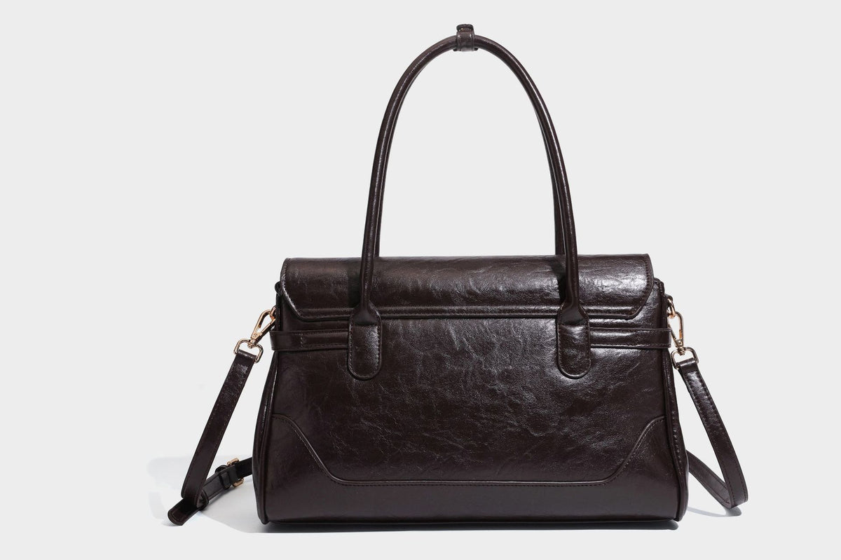 Structured glossy leather-look satchel bag with flap closure, gold-tone buckle accents, double top handles, detachable