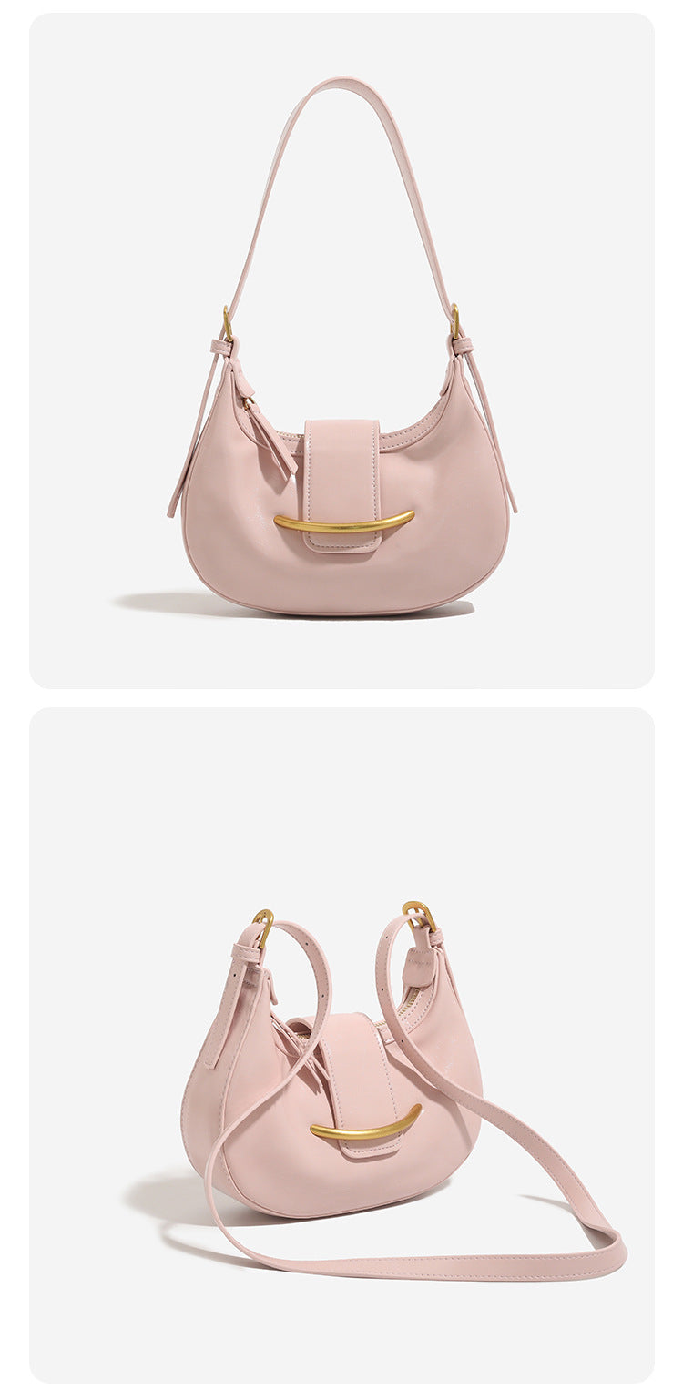 Compact crescent hobo shoulder bag with glossy synthetic finish, curved gold-tone front bar hardware, zip-top closure, and